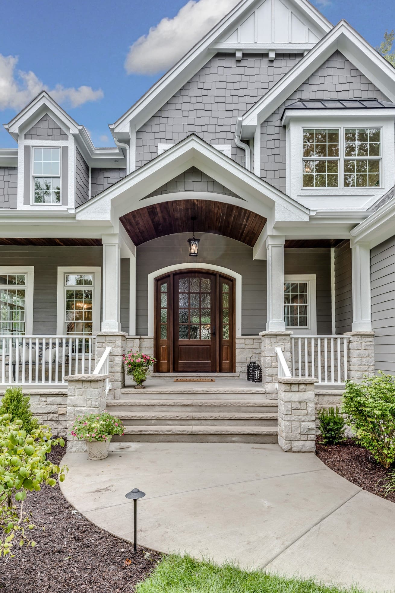 Gray house with wooden front door entrance.